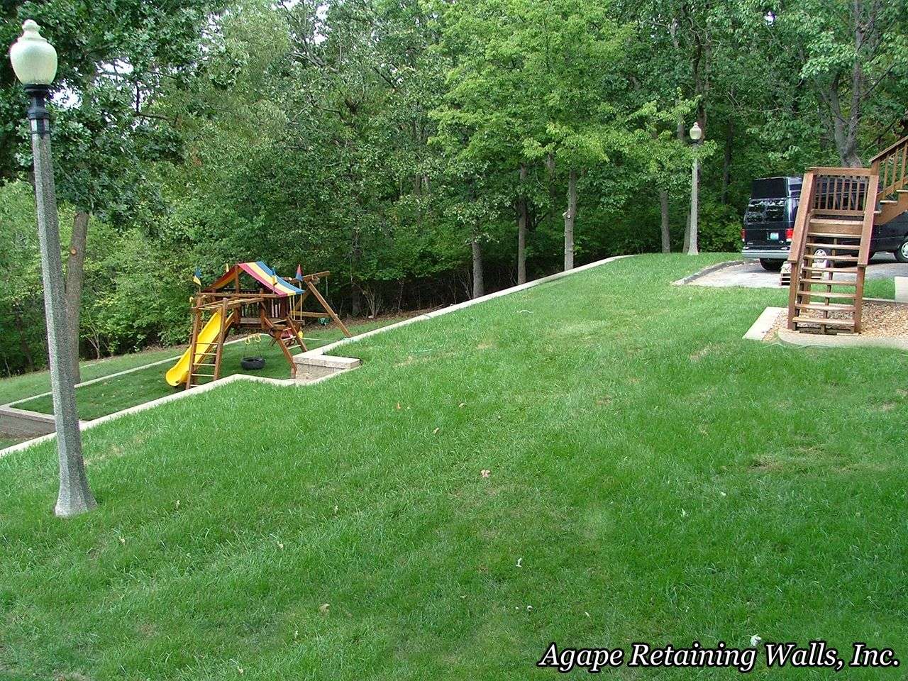 playset on sloped lower yard with retaining wall